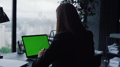 年轻的女商人移动PC绿色屏幕视频调用首页办公室